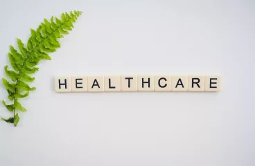 Health Care written by cubic puzzle and a green leaf on left side.